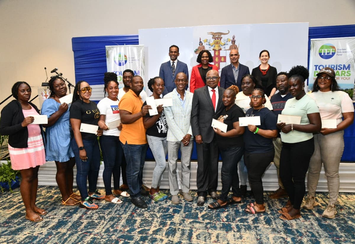 Tourism Minister Hon. Edmund Bartlett presents vouchers to beneficiaries at the THARP launch on December 16, 2025.